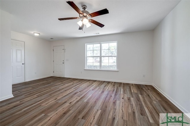 empty room featuring dark hardwood / wood-style flooring and ceiling fan