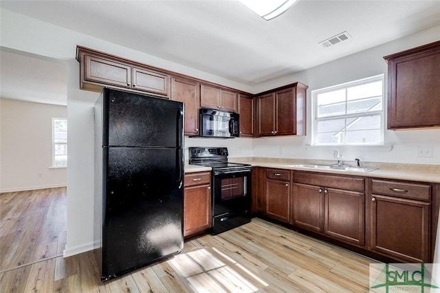 kitchen featuring light hardwood / wood-style floors, sink, and black appliances