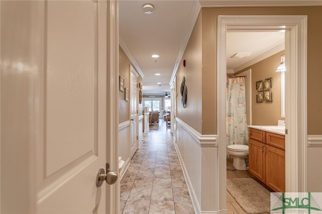 hallway featuring ornamental molding and light tile patterned flooring