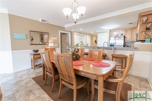 dining area featuring crown molding and a notable chandelier