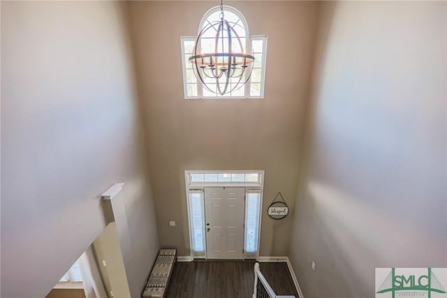 foyer entrance featuring a high ceiling, radiator heating unit, a notable chandelier, and dark hardwood / wood-style flooring