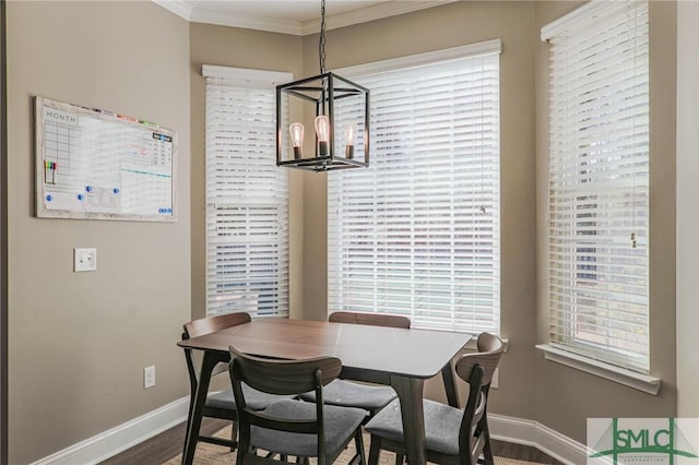 dining space with an inviting chandelier, hardwood / wood-style floors, and crown molding