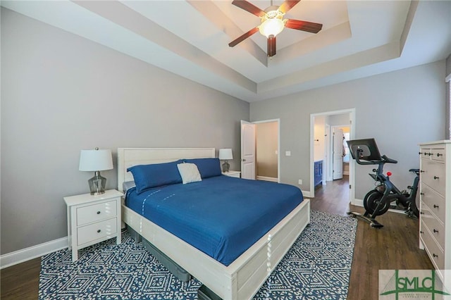 bedroom featuring dark wood-type flooring, ceiling fan, and a raised ceiling