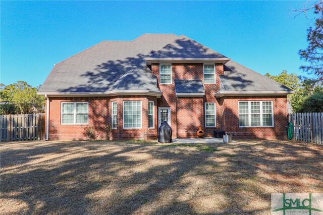 back of property with a yard and a patio area