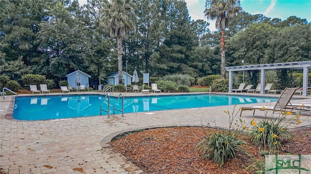 view of swimming pool featuring a shed, a pergola, and a patio