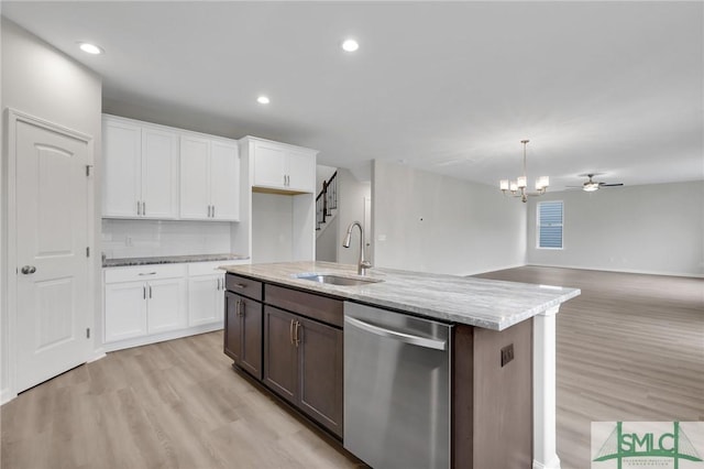 kitchen featuring a sink, white cabinetry, hanging light fixtures, light stone countertops, and dishwasher