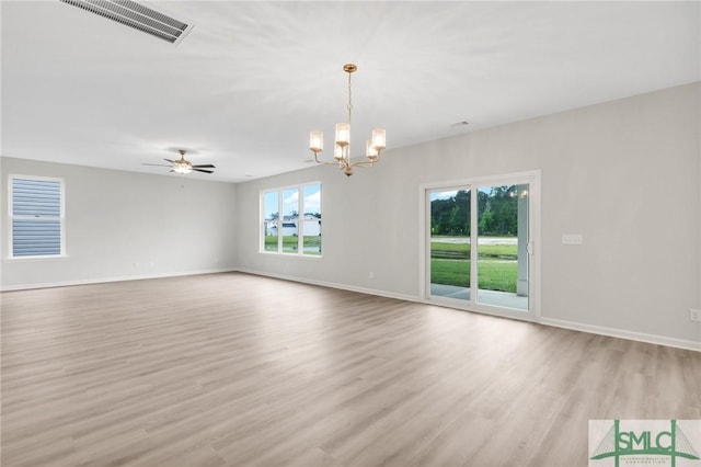 unfurnished room with light wood-style flooring, visible vents, baseboards, and ceiling fan with notable chandelier