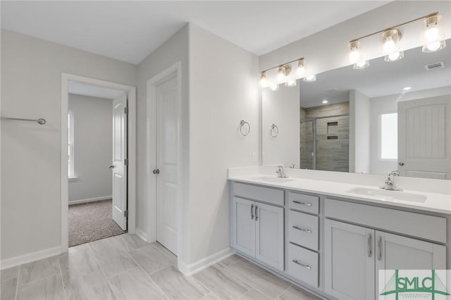 full bathroom with a sink, visible vents, baseboards, a shower stall, and double vanity