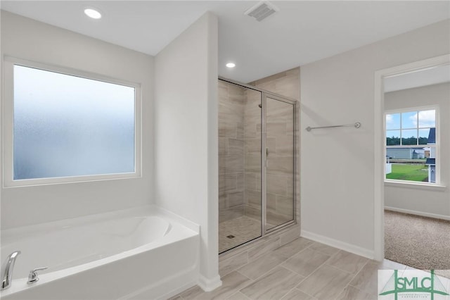 bathroom with a garden tub, recessed lighting, visible vents, a shower stall, and baseboards