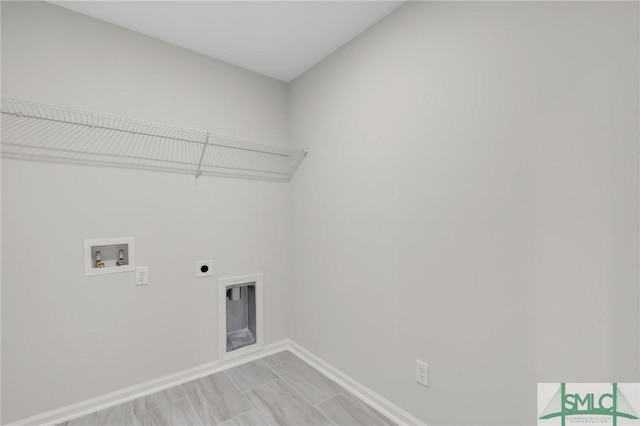 clothes washing area with laundry area, hookup for a washing machine, electric dryer hookup, and baseboards