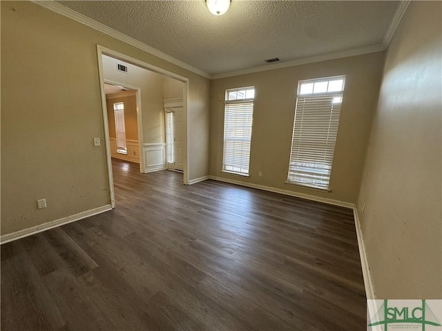 unfurnished room with ornamental molding, a textured ceiling, and dark hardwood / wood-style flooring