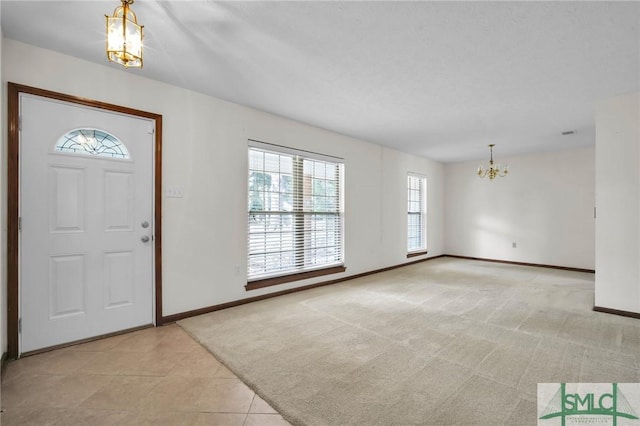 carpeted foyer entrance featuring an inviting chandelier