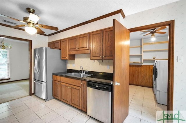 kitchen featuring washer / clothes dryer, sink, light tile patterned floors, stainless steel appliances, and a textured ceiling