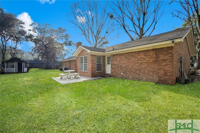 rear view of property featuring a patio, a yard, and cooling unit