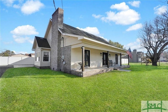 rear view of house featuring a yard