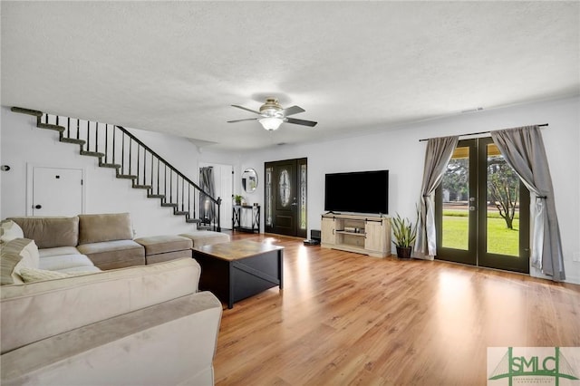 living room with hardwood / wood-style floors, french doors, a textured ceiling, and ceiling fan