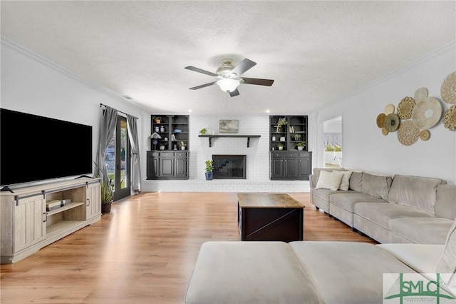 unfurnished living room with light wood-type flooring, a fireplace, a textured ceiling, and built in shelves