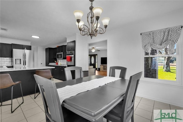 tiled dining area with a chandelier