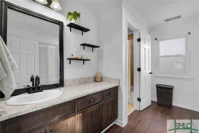 bathroom featuring vanity, wood-type flooring, and ornamental molding