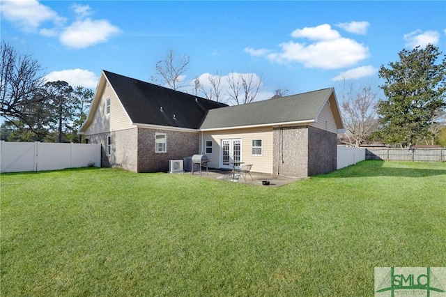 rear view of property with a lawn, a patio area, and french doors