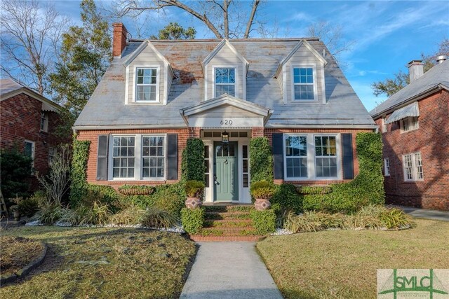 620 E 51st St, Savannah, GA 31405 - cape cod home featuring a chimney, brick siding, and a front yard
