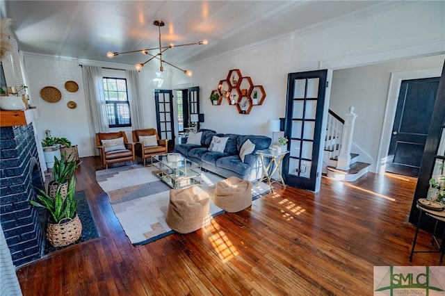 living room featuring hardwood / wood-style floors, a fireplace, ornamental molding, and french doors