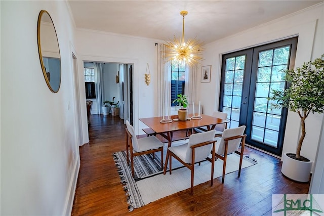 dining area with crown molding, dark hardwood / wood-style floors, french doors, and a notable chandelier