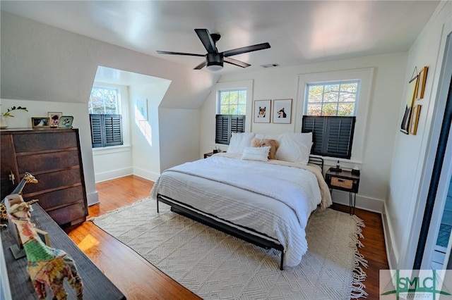 bedroom with ceiling fan, lofted ceiling, and light wood-type flooring