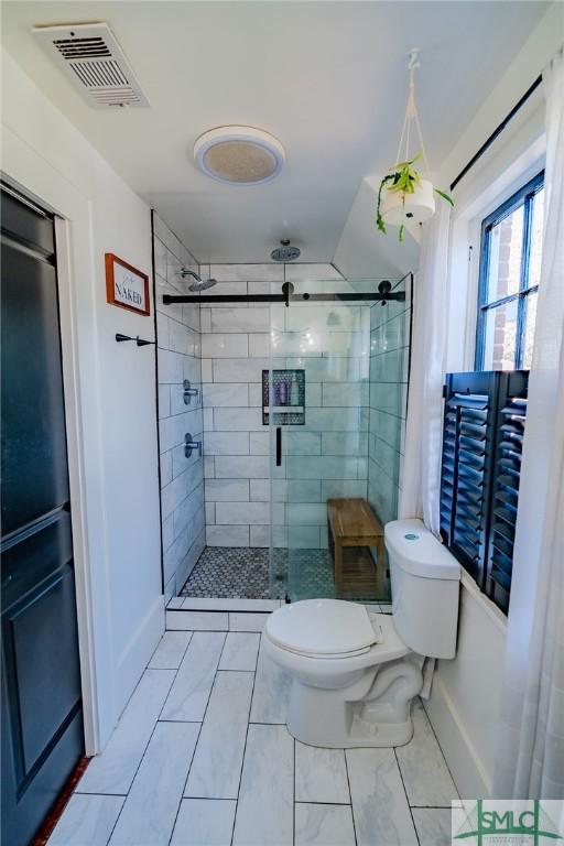 bathroom with an enclosed shower and toilet