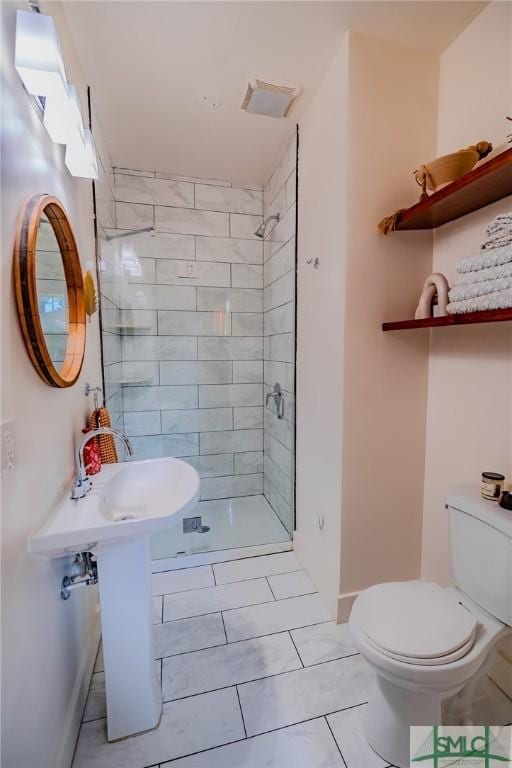 bathroom featuring tiled shower and toilet