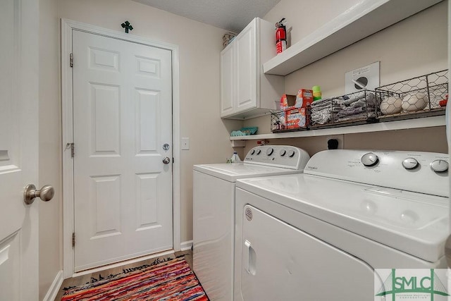 laundry room featuring washing machine and clothes dryer, cabinet space, and baseboards