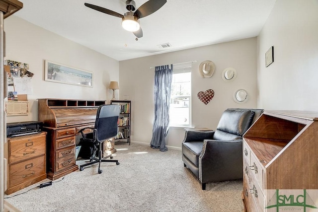 home office with a ceiling fan, light colored carpet, visible vents, and baseboards