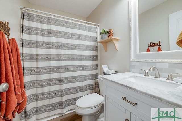 bathroom featuring toilet, a shower with curtain, and vanity