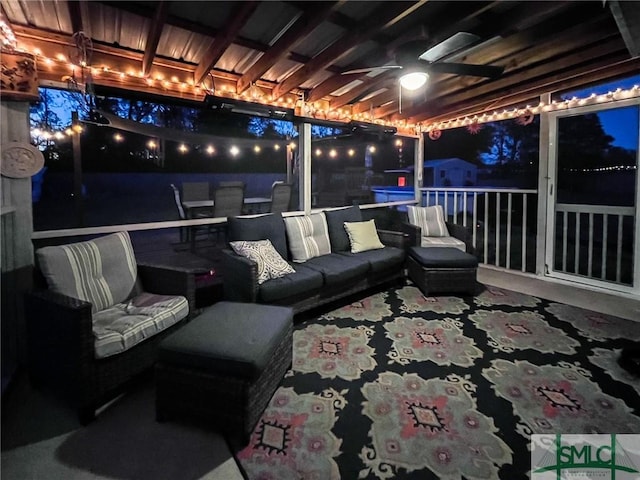 patio at night with ceiling fan and outdoor lounge area