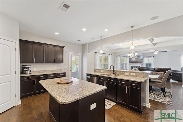 kitchen with sink, a center island, dark brown cabinets, dark hardwood / wood-style flooring, and pendant lighting