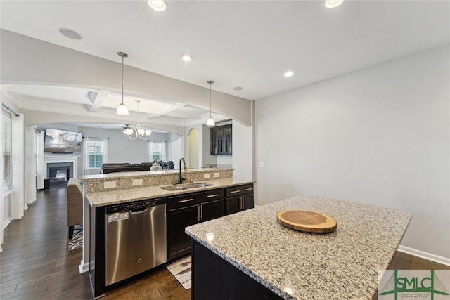 kitchen with sink, a breakfast bar area, decorative light fixtures, stainless steel dishwasher, and an island with sink