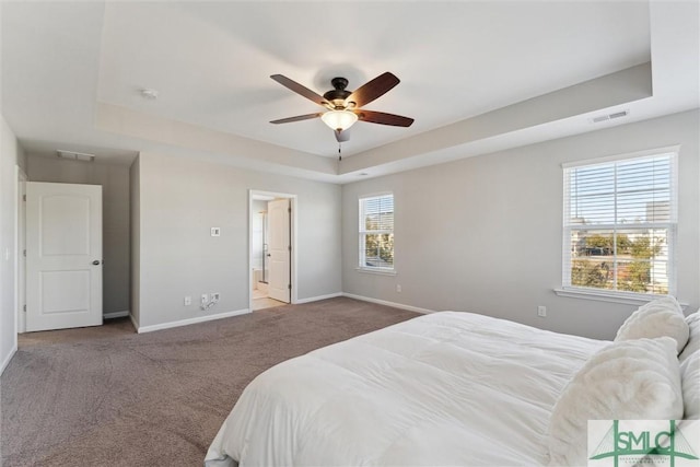 carpeted bedroom with a raised ceiling and ceiling fan