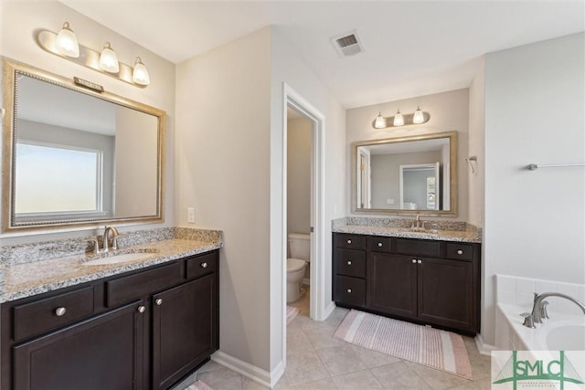 bathroom with vanity, tile patterned floors, a bathtub, and toilet