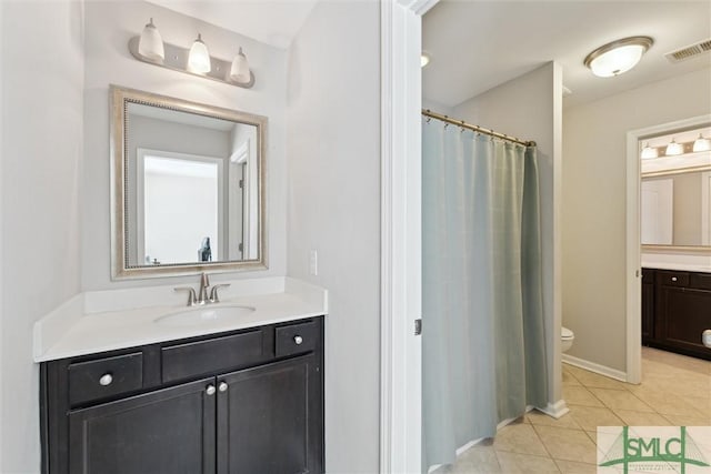 bathroom with vanity, toilet, and tile patterned flooring