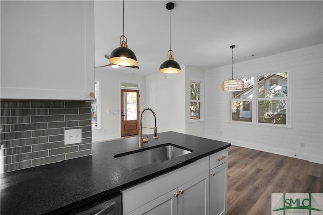 kitchen with sink, white cabinetry, dark hardwood / wood-style floors, decorative backsplash, and decorative light fixtures