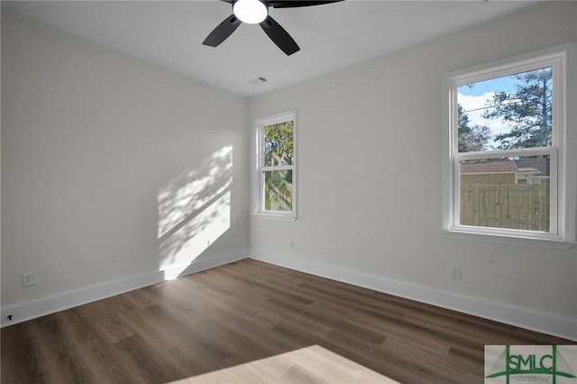 spare room with ceiling fan, dark hardwood / wood-style floors, and a wealth of natural light