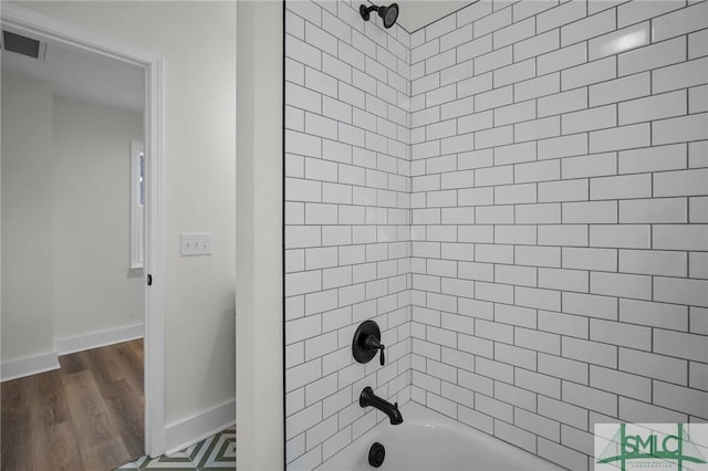 bathroom featuring tiled shower / bath and wood-type flooring