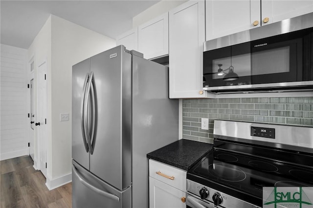 kitchen with stainless steel appliances, dark wood-type flooring, white cabinets, and decorative backsplash