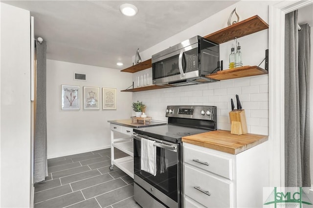 kitchen with stainless steel appliances, white cabinetry, and decorative backsplash