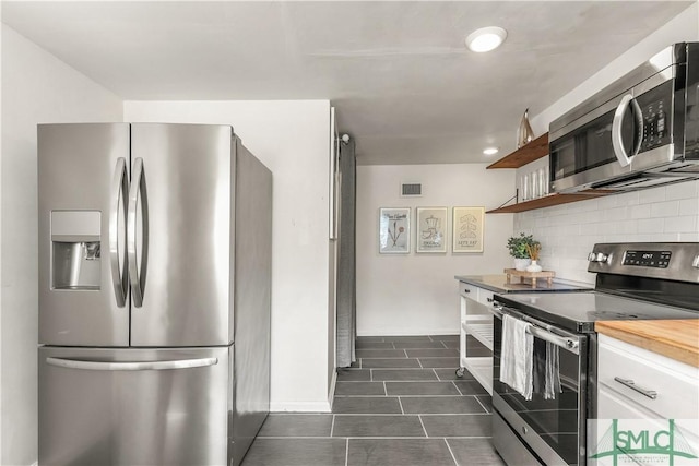 kitchen featuring white cabinetry, stainless steel appliances, and backsplash