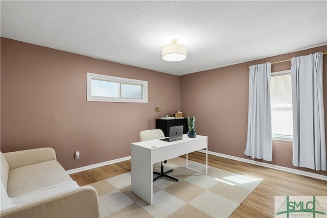 office with a textured ceiling and light hardwood / wood-style flooring