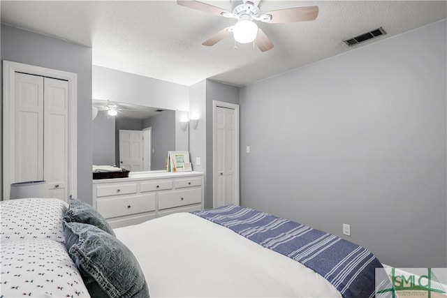 bedroom with ceiling fan and a textured ceiling