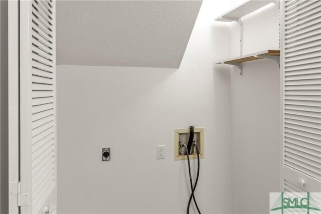 washroom with hookup for a washing machine, a textured ceiling, and electric dryer hookup