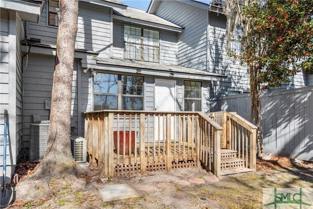 rear view of property with central AC unit and a deck