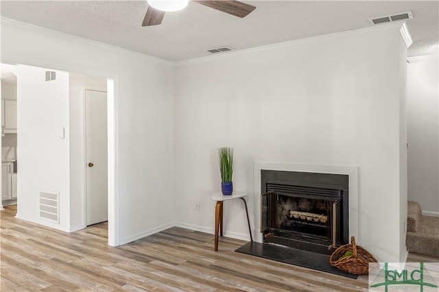 living room featuring crown molding, light hardwood / wood-style flooring, and ceiling fan